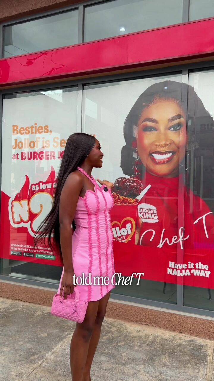 VA in a pink dress outside a Burger King Chef T campaign window
