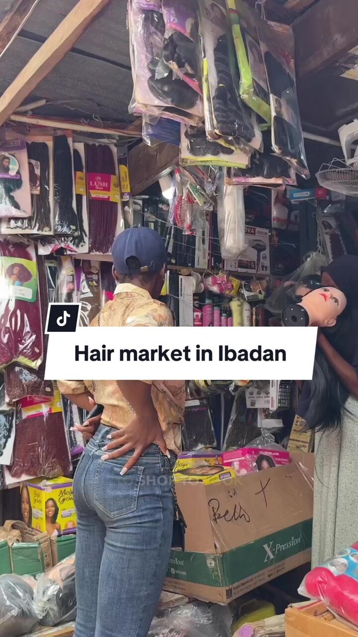 VA browsing a hair market stall in Ibadan
